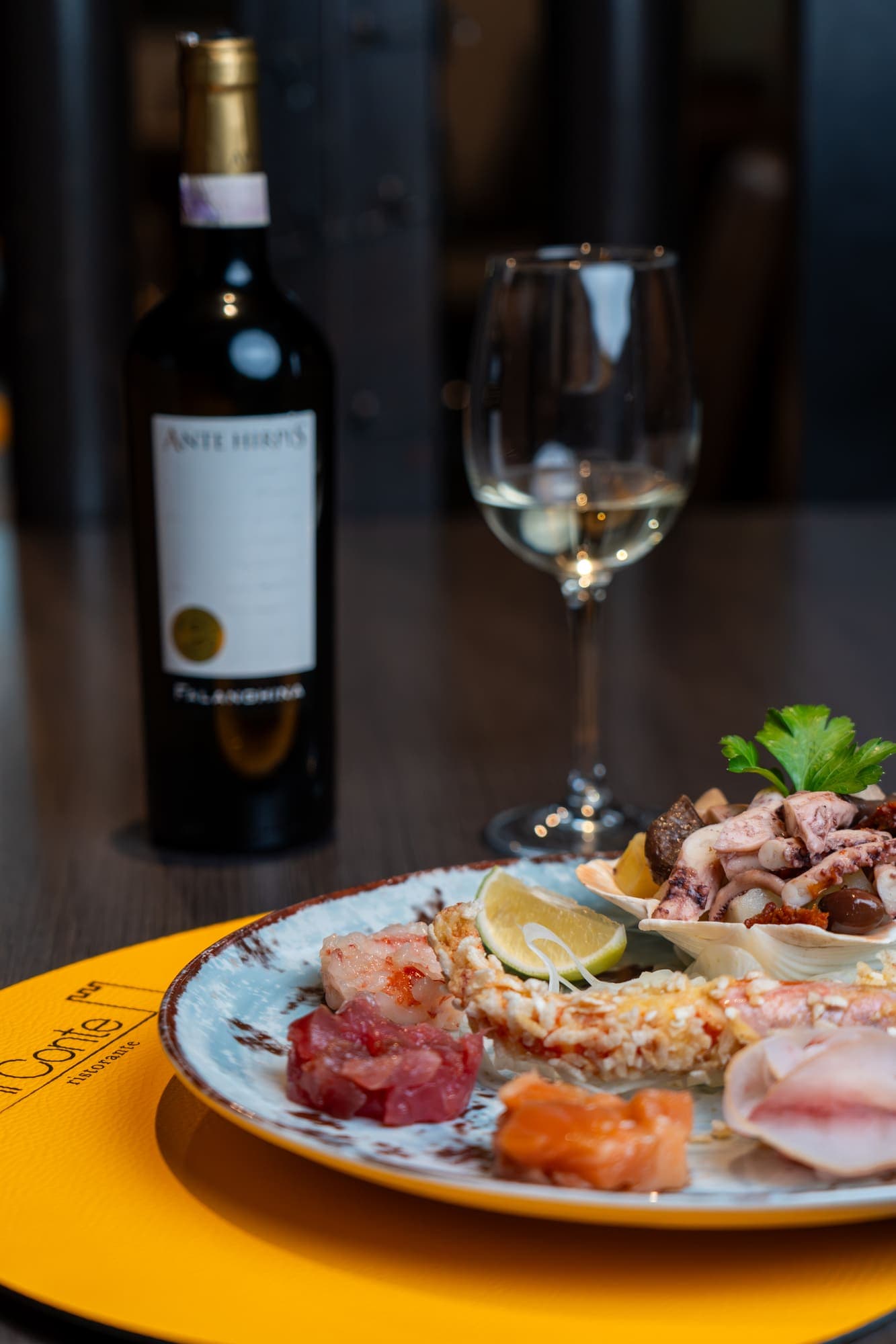 Crudo misto di pesce con tonno, salmone, gambero e polpo, servito con vino Ante Hirpis